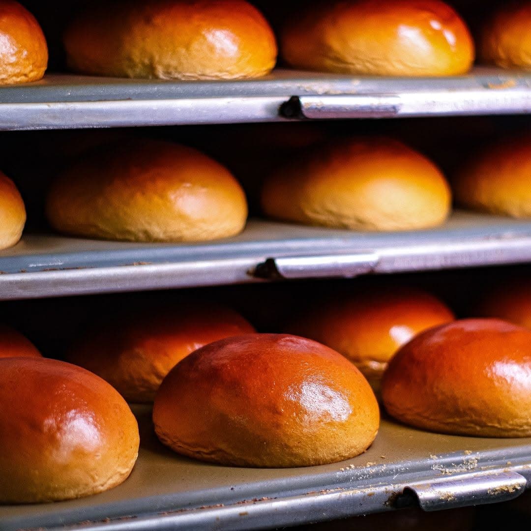 Pães dourados em bandejas de produção